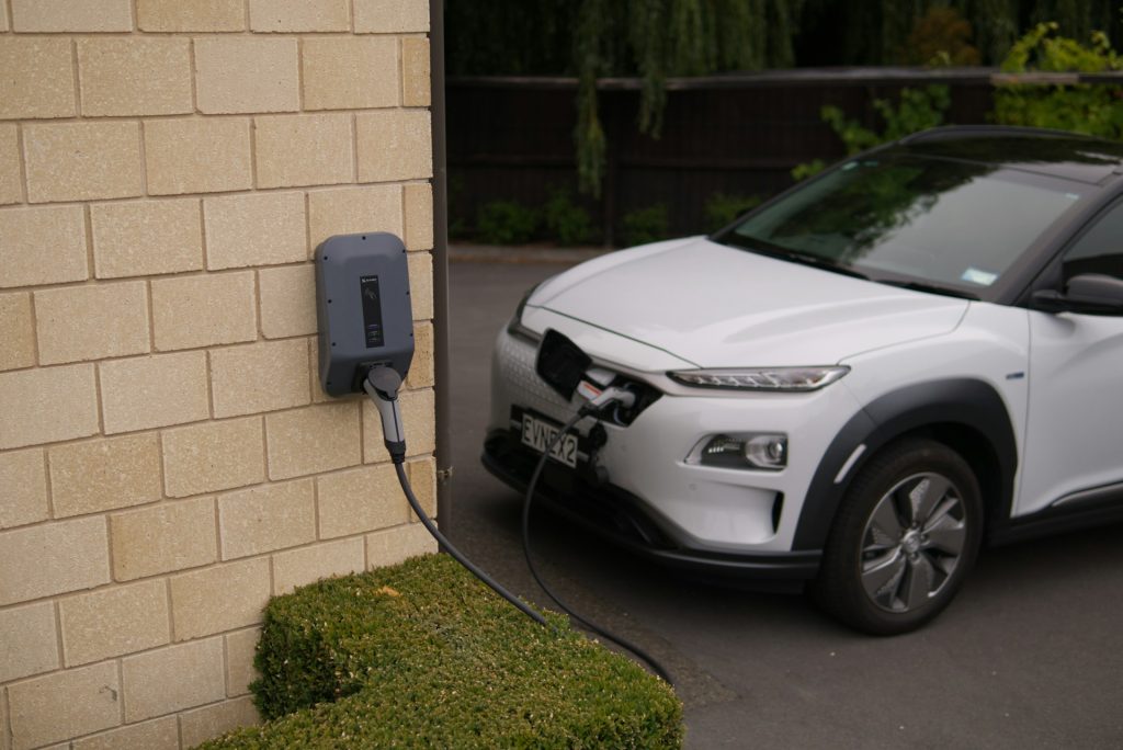 black car parked beside brown brick wall